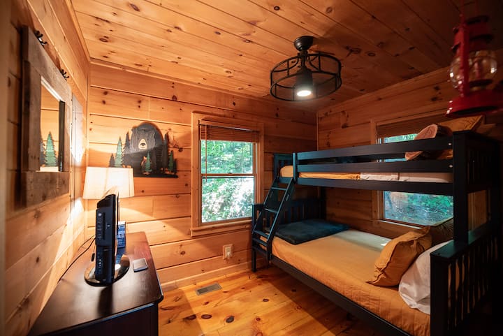 Second bedroom with a twin-over-full bunk bed, forest views and a TV with DVD player.