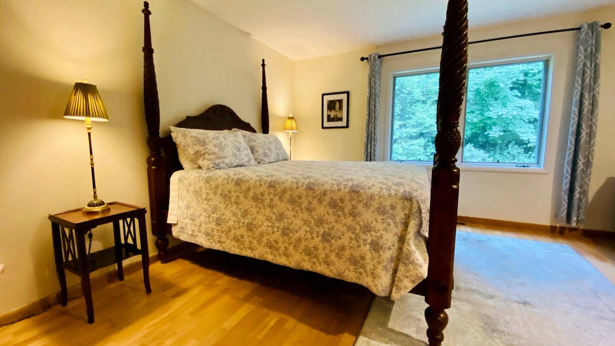 Priestranná spálňa na hlavnom poschodí s manželskou posteľou a veľkým oknom