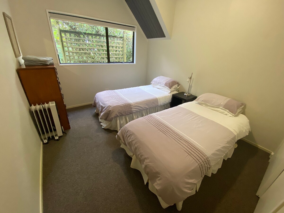 Kjo dhomë gjumi në katin përdhes ka dy krevate teke dhe një gardërobë plot me lodra fëmijësh dhe libra