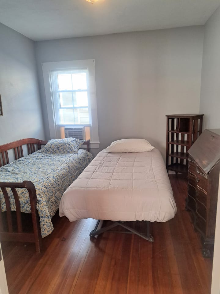 Cama doble y cama nido con espacio de trabajo dedicado.