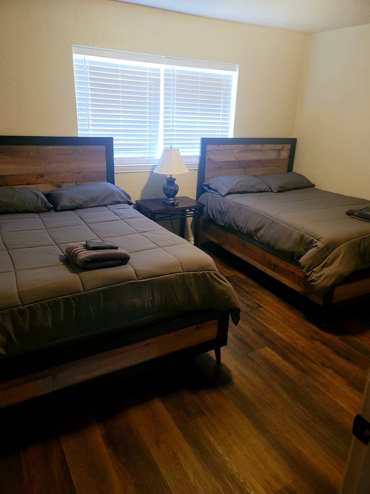 غرفة نوم أولى تضم سريرين مزدوجين