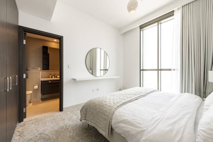 El dormitorio secundario también cuenta con una cama tamaño king y un espejo grande junto con un estante y un armario grande.