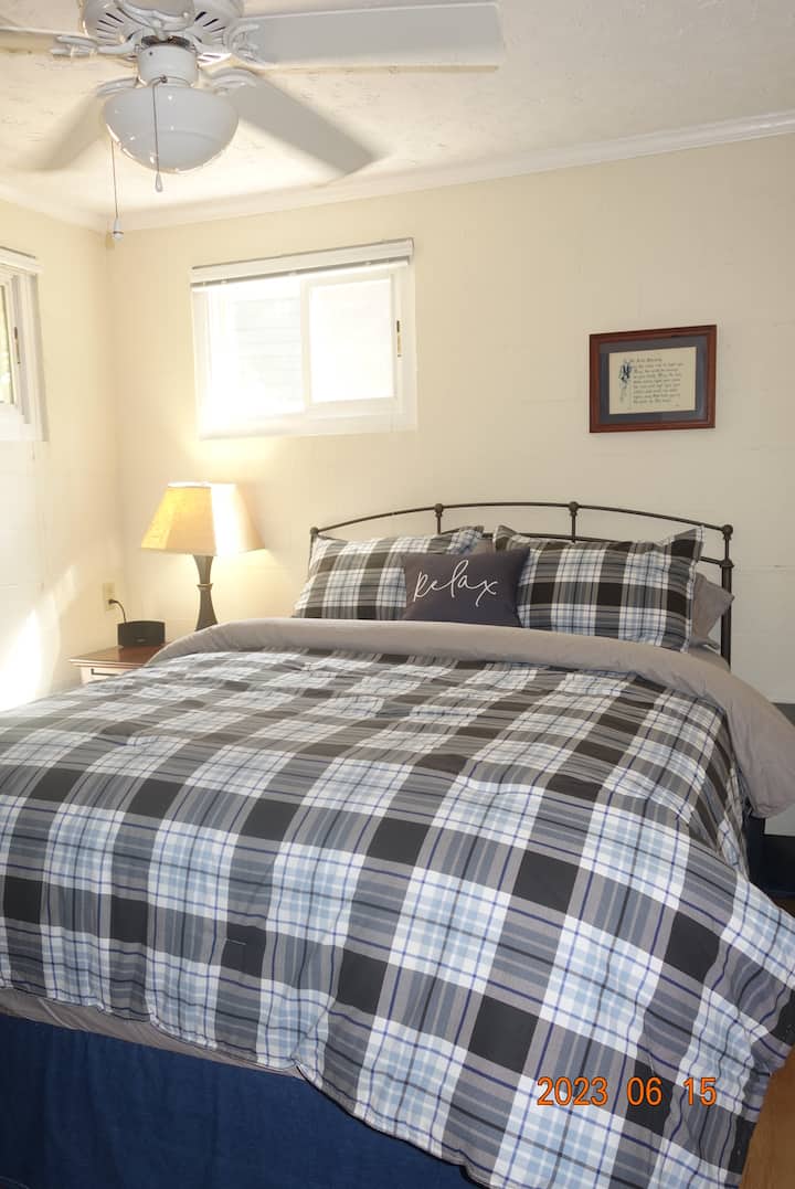 غرفة النوم رقم1 مع سرير بحجم كبير وصدر وخزانة صغيرة ومروحة سقف