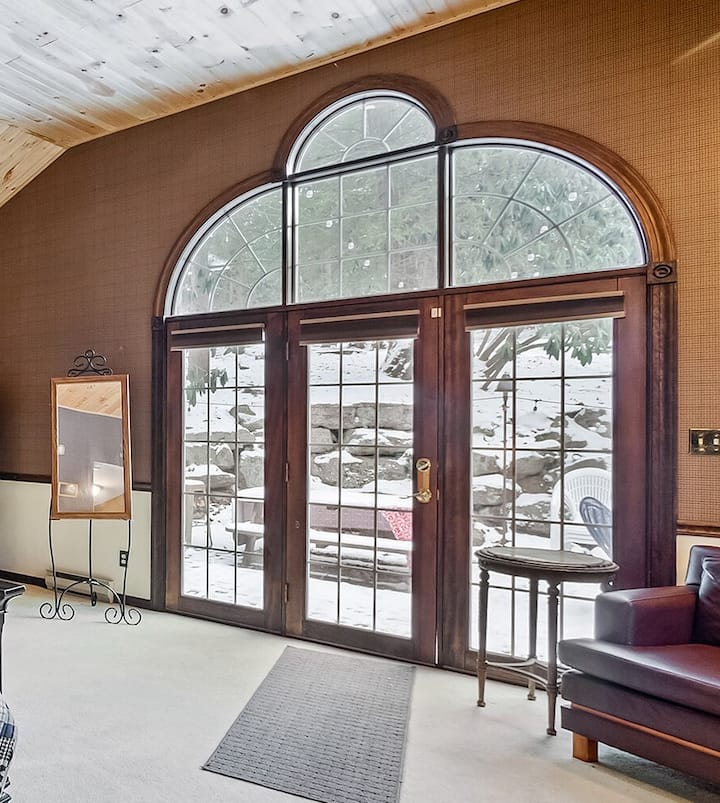 Dhomë gjumi e madhe kryesore me derë/dritare të madhe prej xhami që shikon oborrin e pasmë.  Vaskë xhakuzi në dhomën e gjumit 
Pamjet e dimrit nga krevati janë mjaft në rregull :)