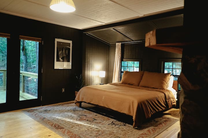 Chambre principale en bas avec surmatelas King Tuft & Needle et salle de bain attenante. Les portes vitrées mènent à l'immense terrasse !