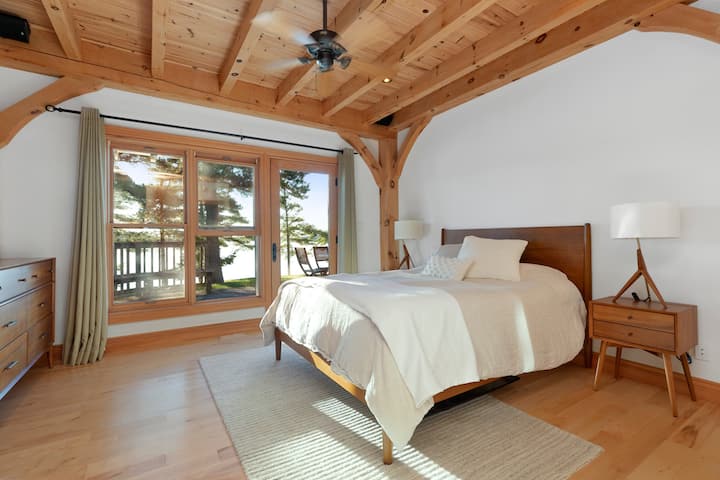 Dormitorio principal con chimenea de gas, televisión,  baño privado, porche y mesa de bistró.