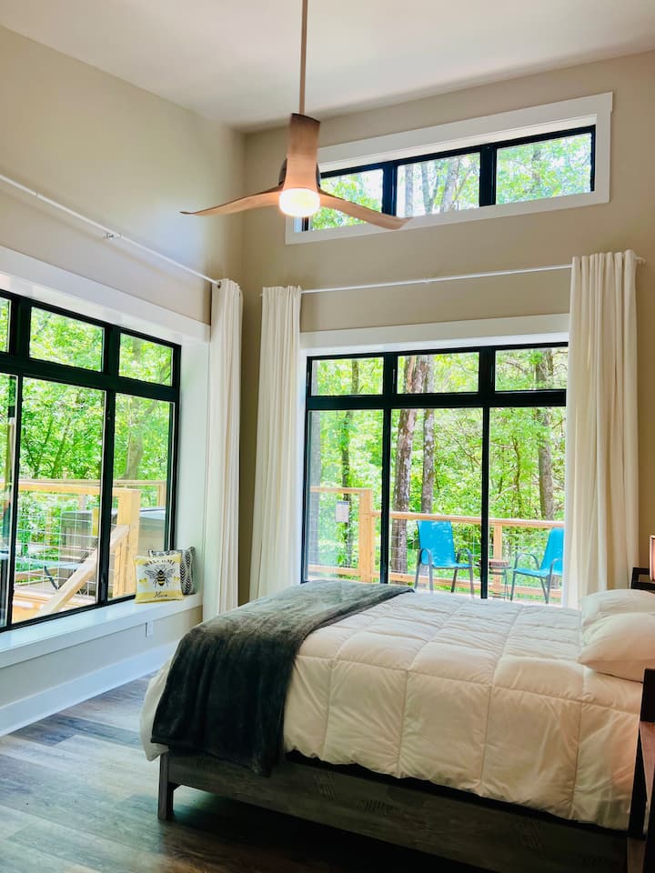 Chumba cha kulala cha mashariki kilicho na madirisha makubwa na kitanda kipya chenye starehe sana chenye feni ya dari. 