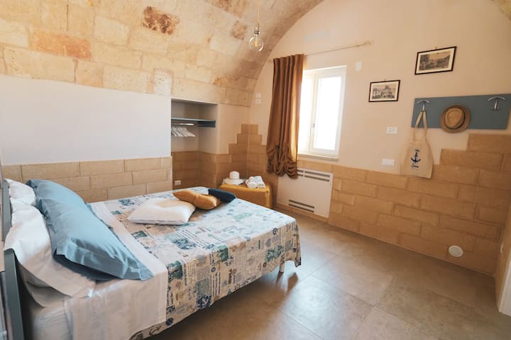 Zona e gjumit me një krevat dopio me madhësi standarde dhe një puf që hapet për t'u bërë një krevat tek.