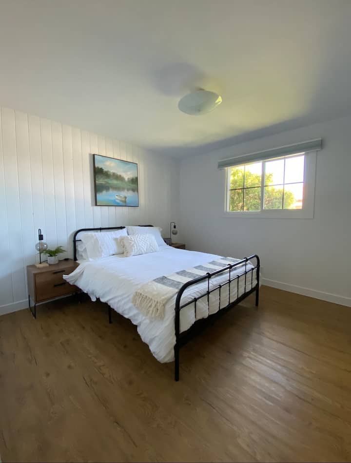 ห้องนอนหลักพร้อมเตียงควีนไซส์มู่ลี่สีดำและวิทยุบลูทูธ 