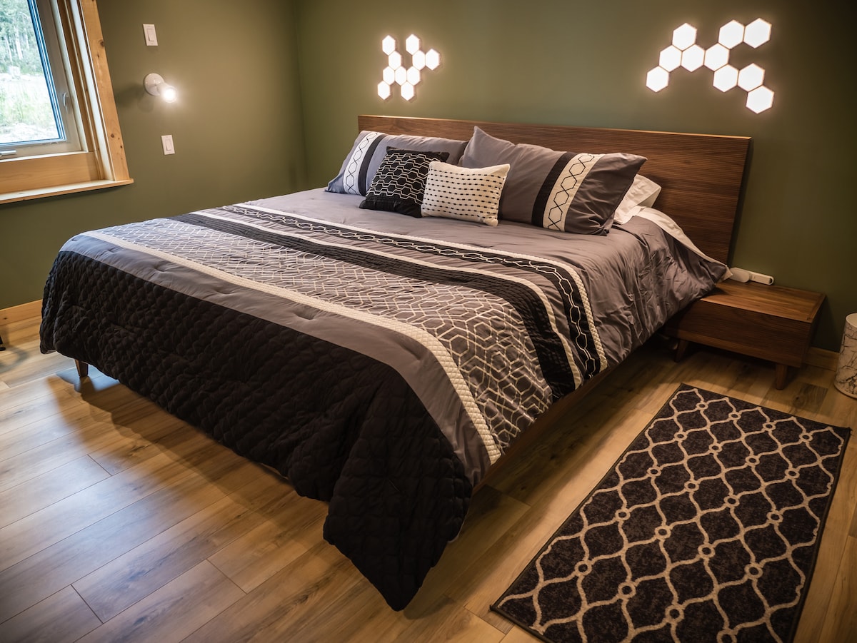 King Size Bedroom
Includes nightstands, dressers, and 55″ TVs. The bedrooms are decorated with modern, minimalist furniture.