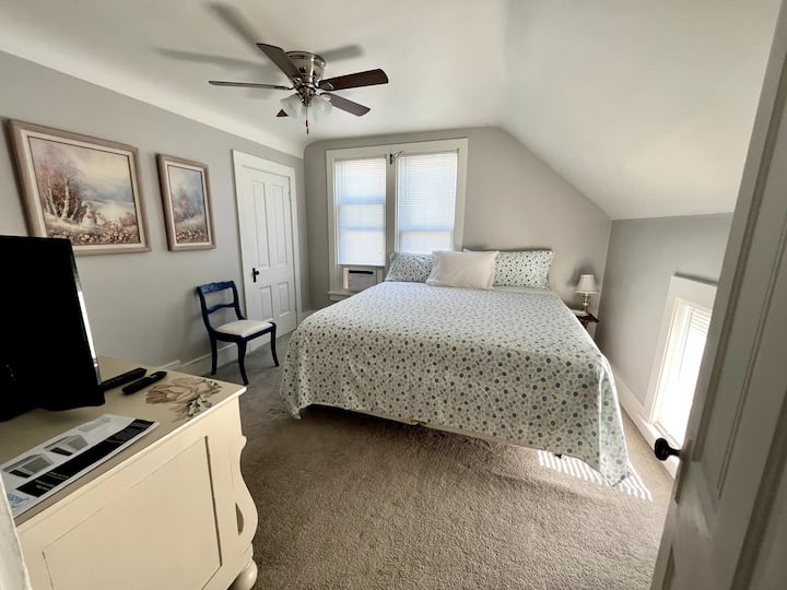 เตียงคิงไซส์ในห้องนอนสีเทาชั้นบน