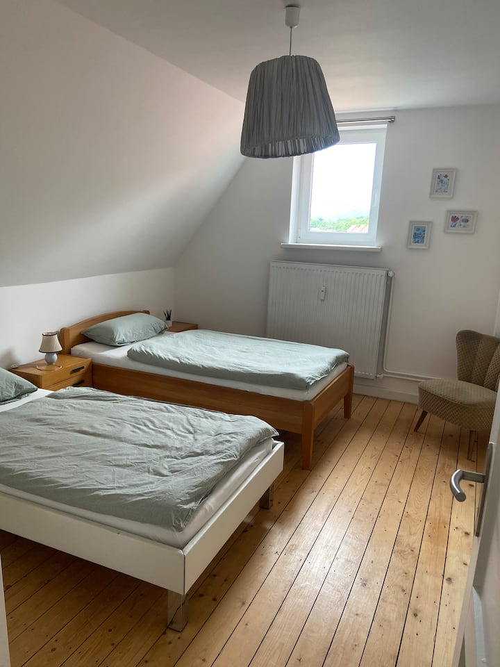 Upper bedroom (left) with two single beds