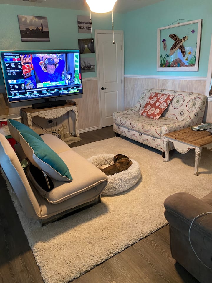 Il soggiorno si trova appena fuori dalla zona pranzo. Oltre al piccolo divano e al futon, ci sono due sedie a sdraio con bracciolo al centro. Cane non incluso. 