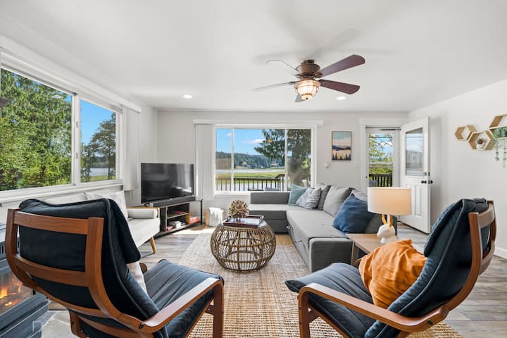 غرفة معيشة واسعة بإطلالة على الفناء الخلفي والبحيرة