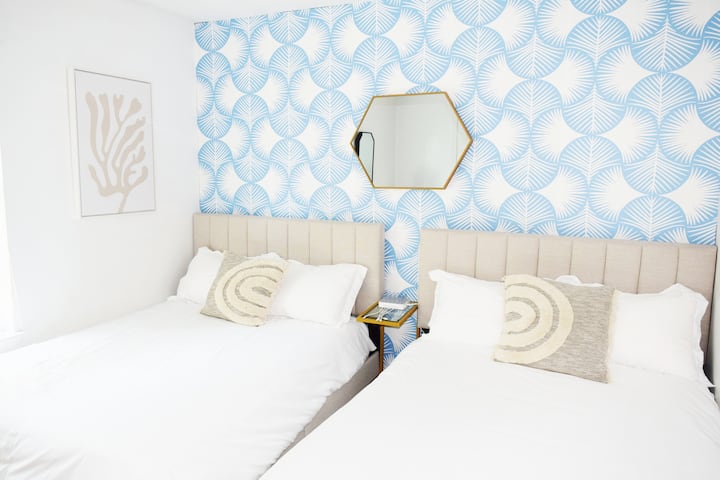 El dormitorio cuenta con un diseño moderno con papel tapiz personalizado, dos camas completas con colchones de espuma viscoelástica, un televisor inteligente, una cómoda y un armario grande. Este elegante espacio es perfecto para huéspedes que buscan comodidad y conveniencia cerca de Navarre Beach en la costa del Golfo.