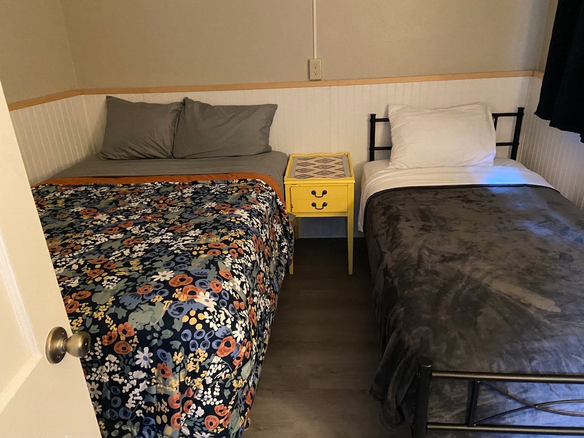 Სრული საწოლი და ორადგილიანი საწოლი საძინებელში.