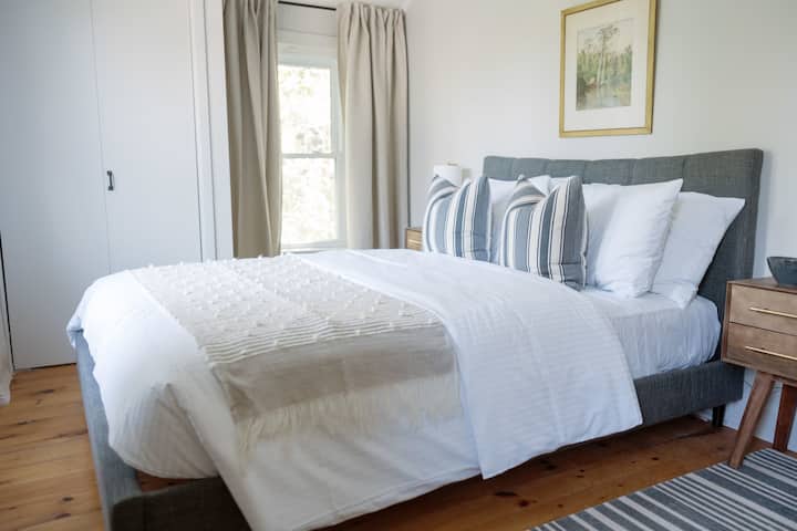 ห้องสีเทามีเตียงควีนไซส์พร้อมผ้าปูที่นอนนุ่มและหรูหราพร้อมวิวป่า 