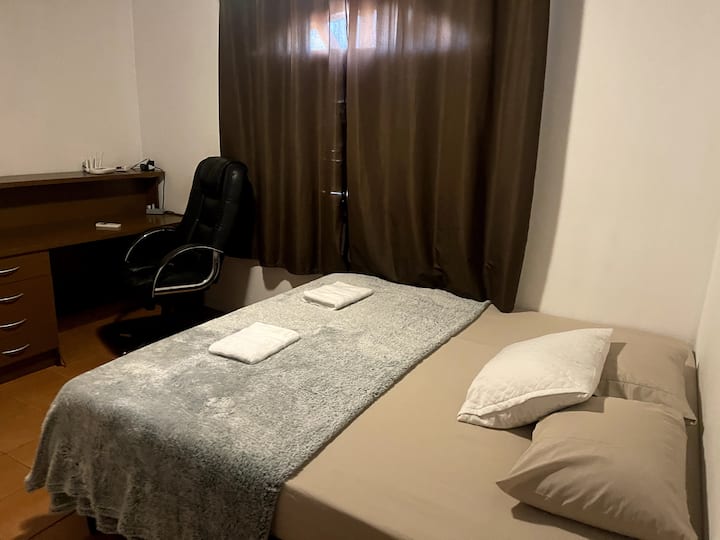 Chumba, kitanda cha ukubwa wa Emma King, feni, kiyoyozi na kompyuta ya mezani iliyo na kiti cha kazi