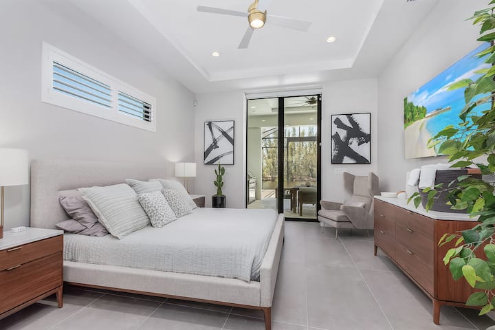 Dormitorio tamaño king con baño privado y acceso al lanai, hermosos muebles, sábanas, batas y toallas.