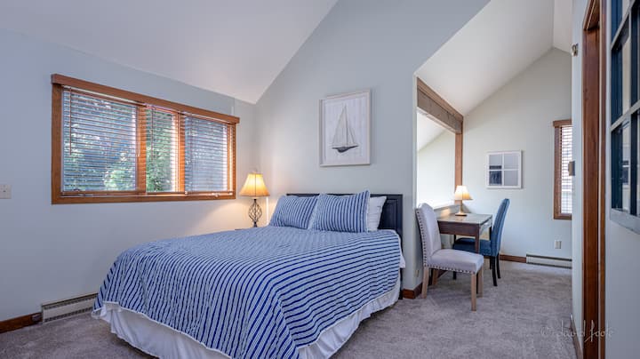 Queen size bed in our loft with bathroom and Smart ROKU TV.