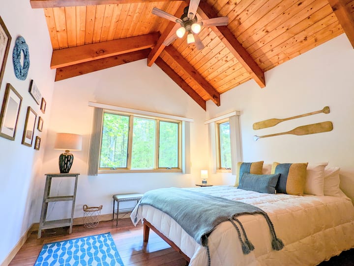 The upstairs "Summer Room" features a gallery wall, plenty of closet storage, and even a peekaboo-view of Lake Sunapee.