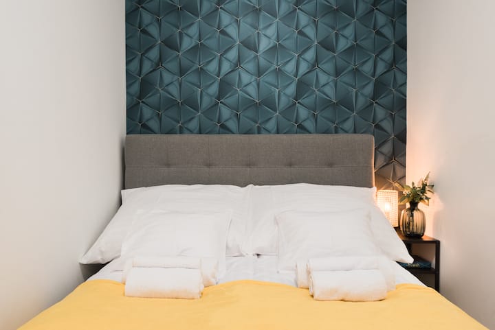 Udoban i širok bračni krevet s kvalitetnom posteljinom i zlatnim prekrivačem. 