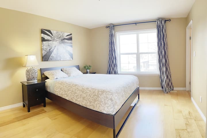 غرفة نوم رئيسية في الطابق الرئيسي بسرير بحجم كوين