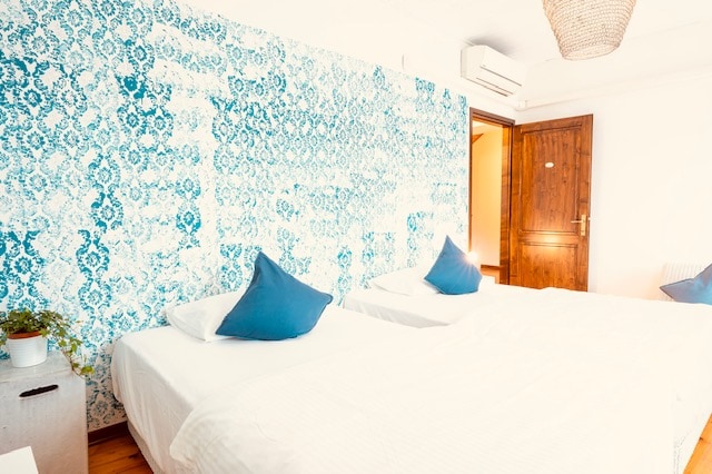 חדר מואר עם שתי מיטות שיש לבנות, כיכר אחת ועטלפים כל אחת שניתן לחבר למיטת קינג