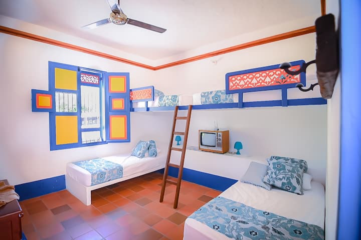 Soba na prvom katu s 4 kreveta za jednu osobu u kojoj je ljepota kolonijalne arhitekture pomiješana s prostornom raspodjelom suvremenog dizajna.