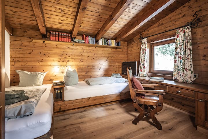 Gästezimmer mit zwei Einzelbetten und Balkon.