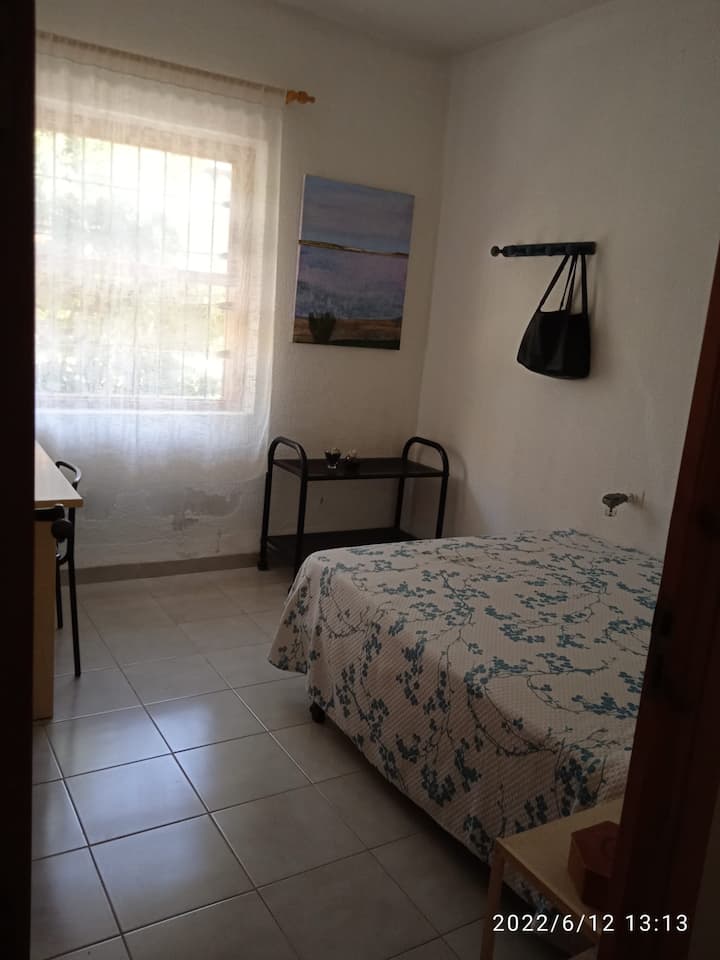 غرفة نوم ثانية بسرير مزدوج وطاولة دراسة.