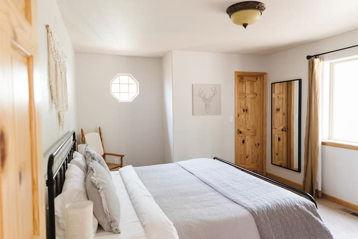 Primary Room with King Bed, full length mirror, and connected bathroom