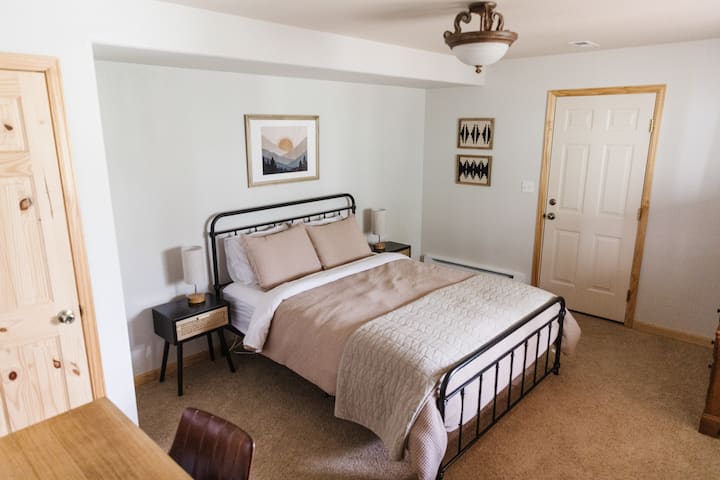 The downstairs bedroom has a comfy queen bed, as well as a desk for those who need to work or write during their stay. The print above this bed is also one of my favorites.