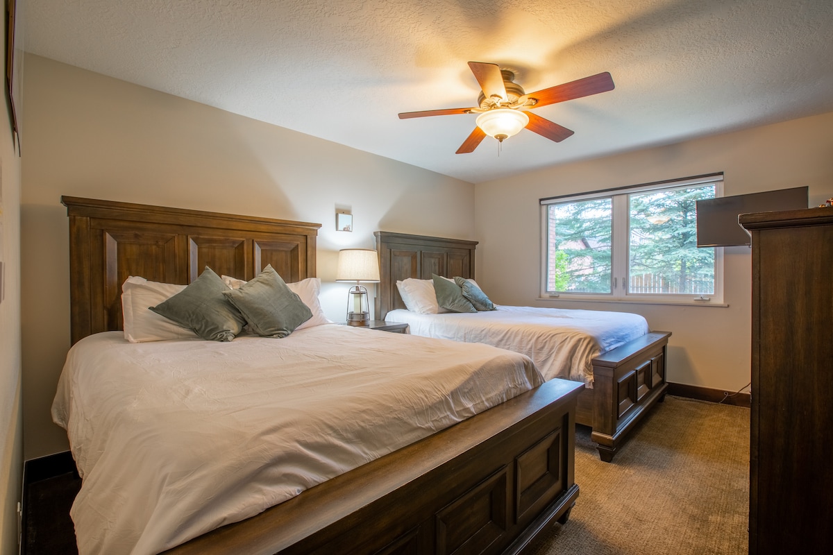 เตียงควีนไซส์ 2 เตียงพร้อมเครื่องนอนสบายทีวีและโต๊ะเครื่องแป้งล้อมรอบห้องนอนที่สองสำหรับครอบครัวหรือเพื่อน 