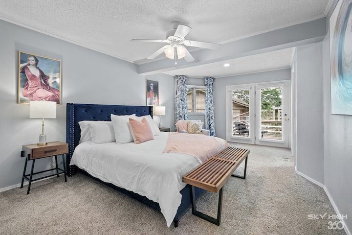 Mäkká a relaxačná posteľná bielizeň v hlavnej izbe s prístupom na zadnú verandu a priestor s vírivkou. 