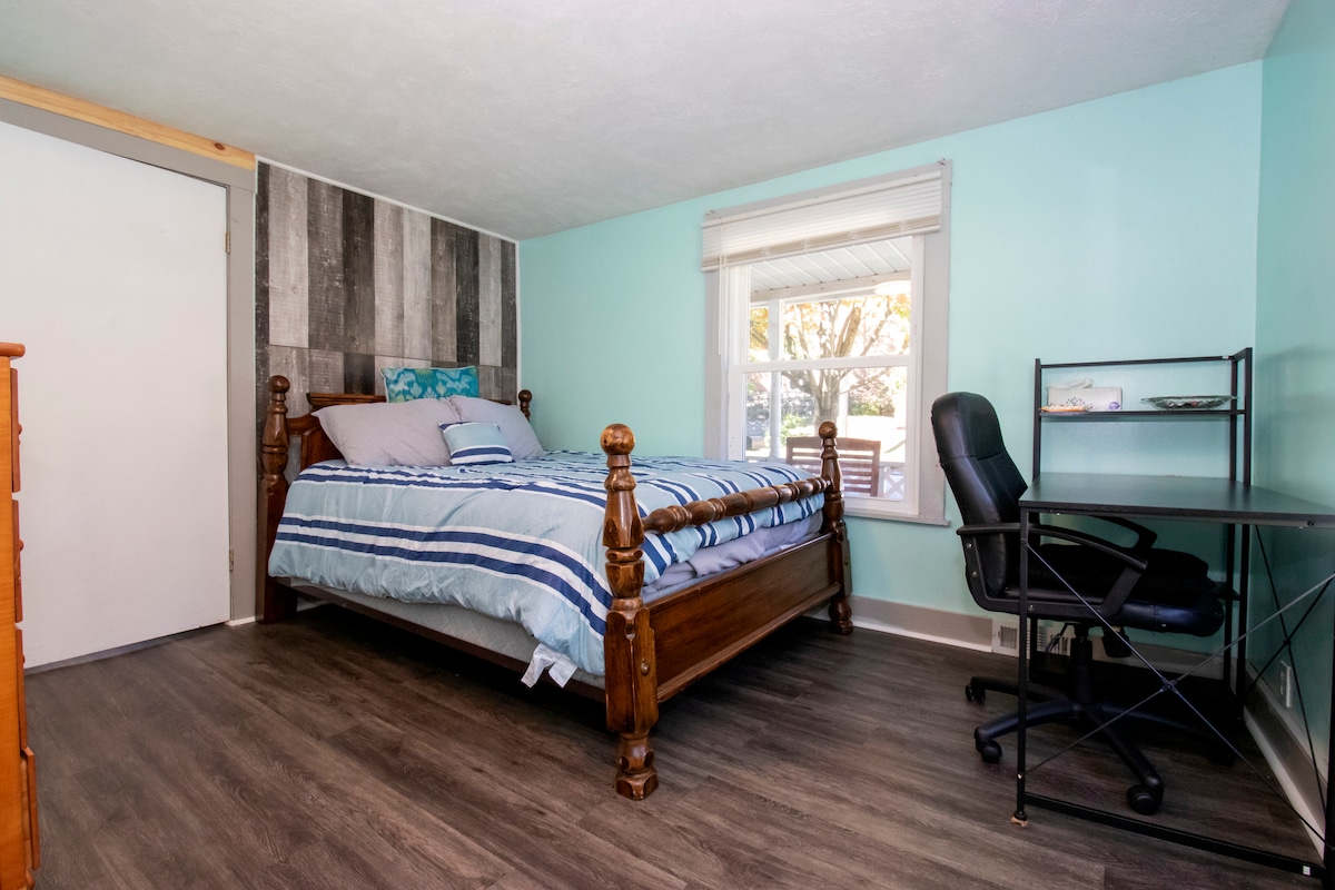 Chambre avant avec lit queen size, bureau pour ceux qui voyagent et qui ont besoin d'un espace de travail.