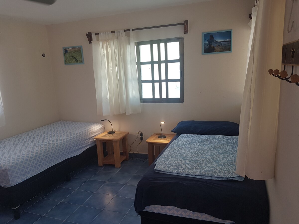 Spavaća soba okrenuta prema plaži s klima-uređajem i kupaonicom.