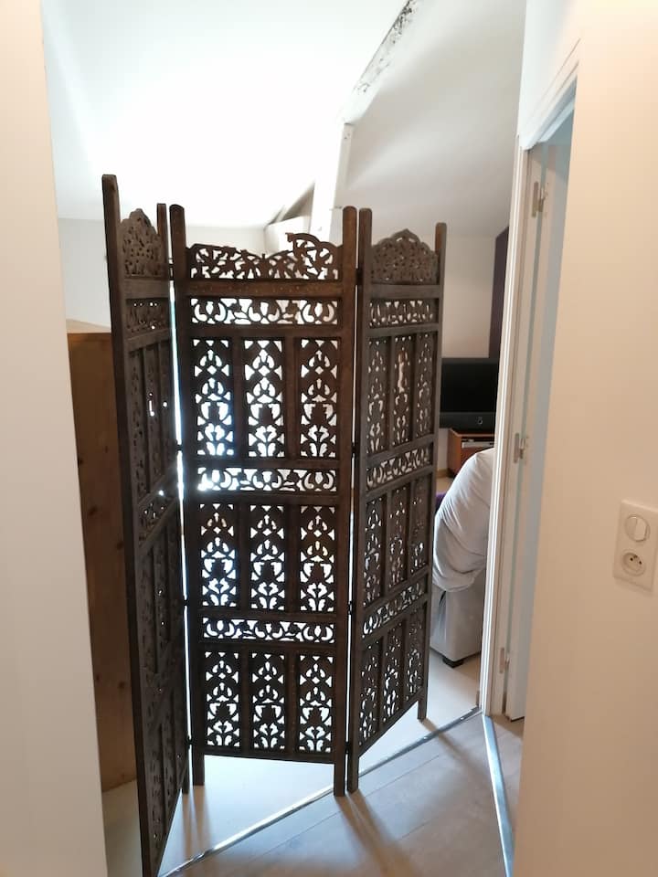 Dhomë gjumi pa derë, por e pajisur me një ekran për privatësinë. Ka një televizor dhe një tavolinë pune