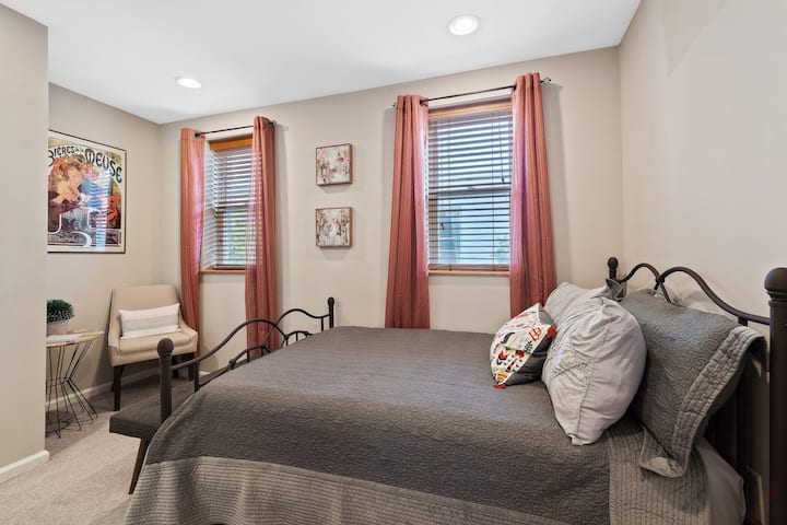 Chumba cha kulala cha kimtindo na tulivu chenye rangi ya udongo, mwangaza wa joto na mapambo yaliyopangwa kwa uangalifu.
