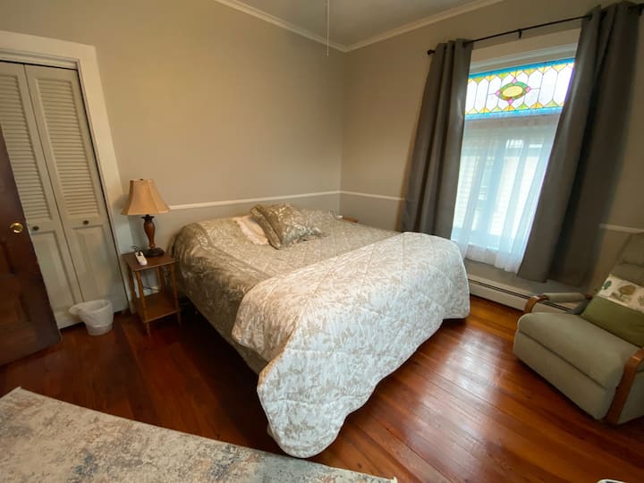 2e verdieping,  slaapkamer #1  ruime kamer met een kingsize bed, schommel fauteuil, dressoir, kast en een 43inch Samsung smart-tv  