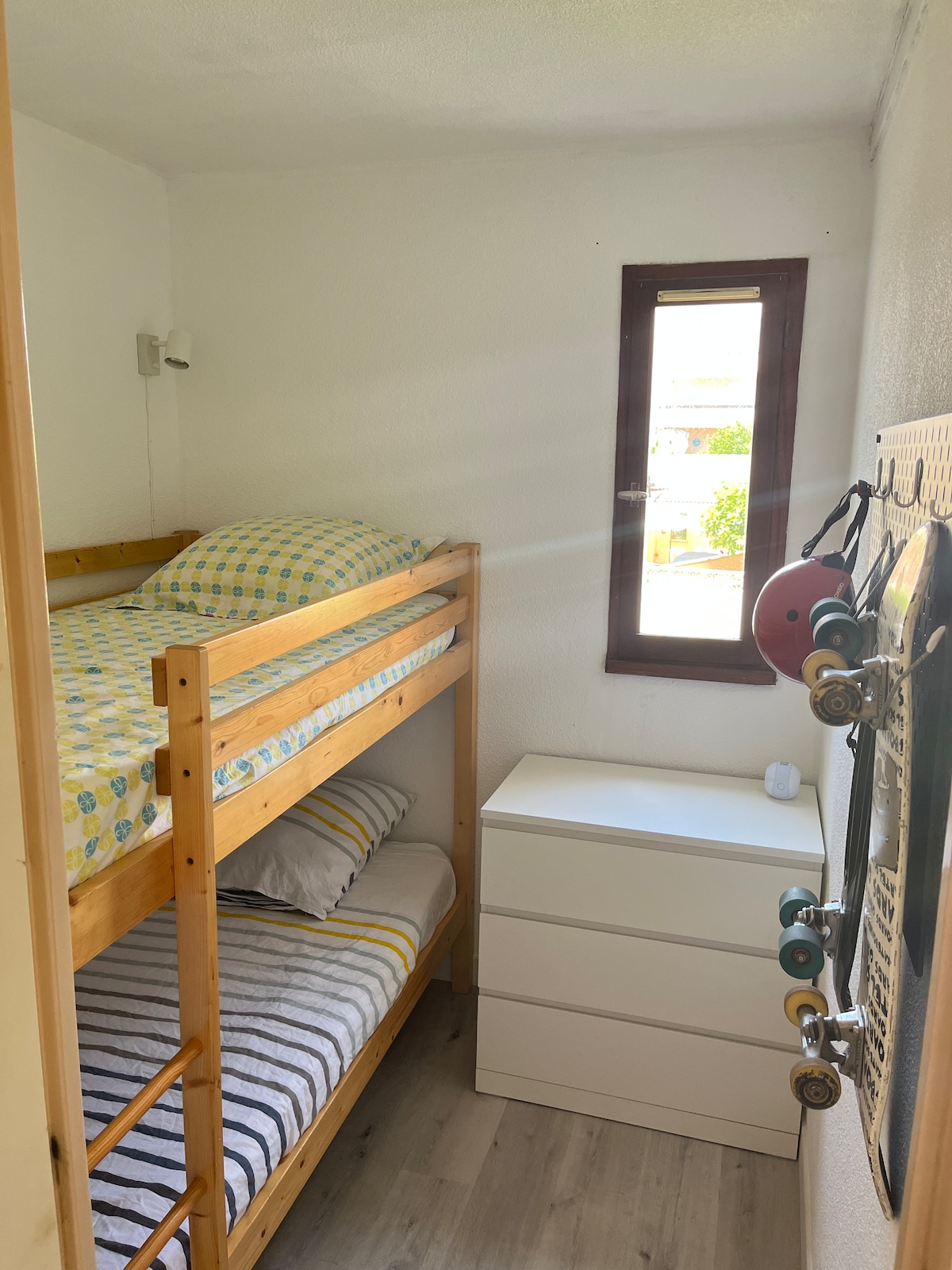 Спалната соба со кревет на спрат 90 x 190 см, гардеробер за чување на облеката и скејтборди за јавачите.