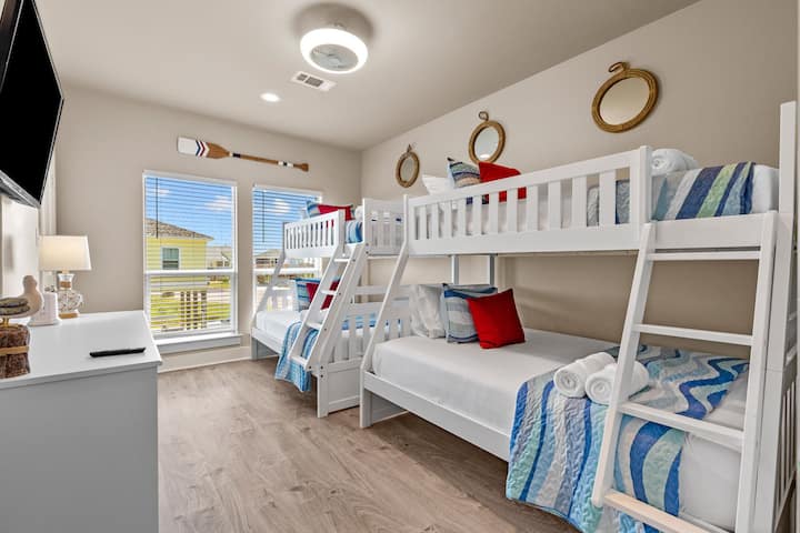 2nd bedroom 2 sets of twin over full bunk beds with beautiful nautical decor, remote controlled ceiling fan and box fan as well as an LED backed smart TV. 