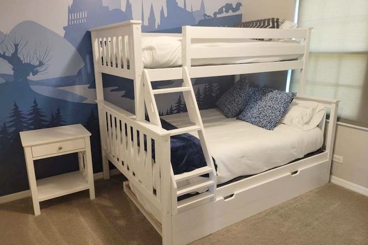 Upstairs bunk room with twin bed on top, double bed on bottom, and twin trundle