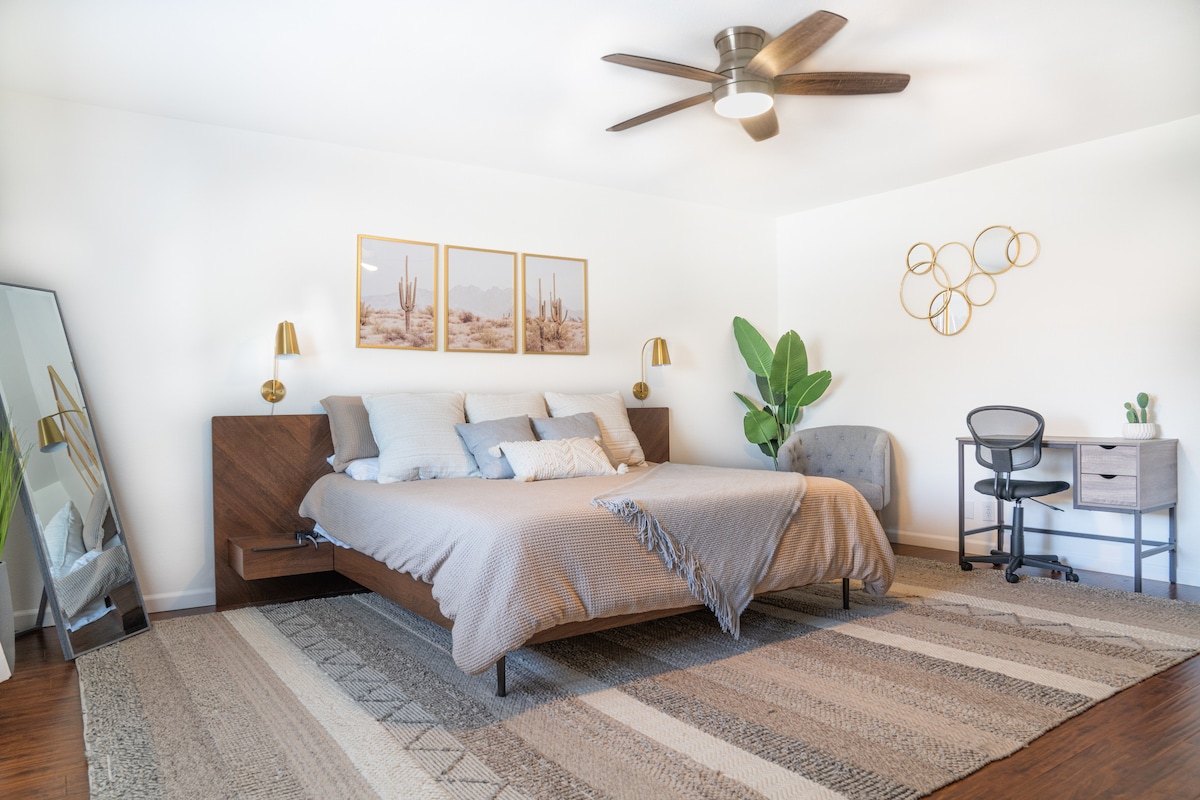 Chumba cha kulala cha msingi kilicho na kitanda aina ya king, tembea kwenye kabati, chumba cha kulala, dawati na televisheni ya "55"