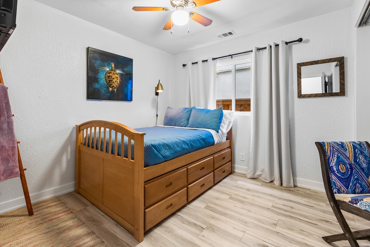 Პირველი საძინებელი ორადგილიანი საწოლი და ორადგილიანი საწოლი, კედლის ხელოვნება და 15 ვატიანი თავზე საკითხავი ლამპა. 