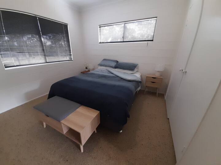 A very tidy queen bedroom with new furniture and top-floor view out over the farm and bushland.