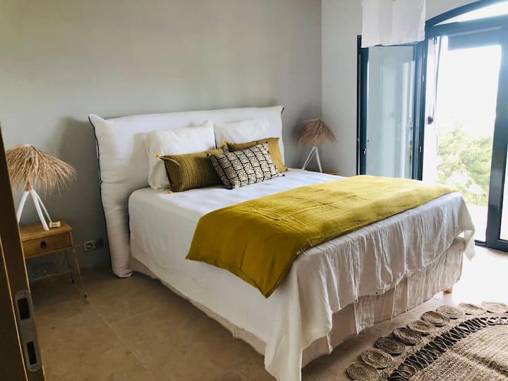 una suite con baño y  terraza con vistas al mar 