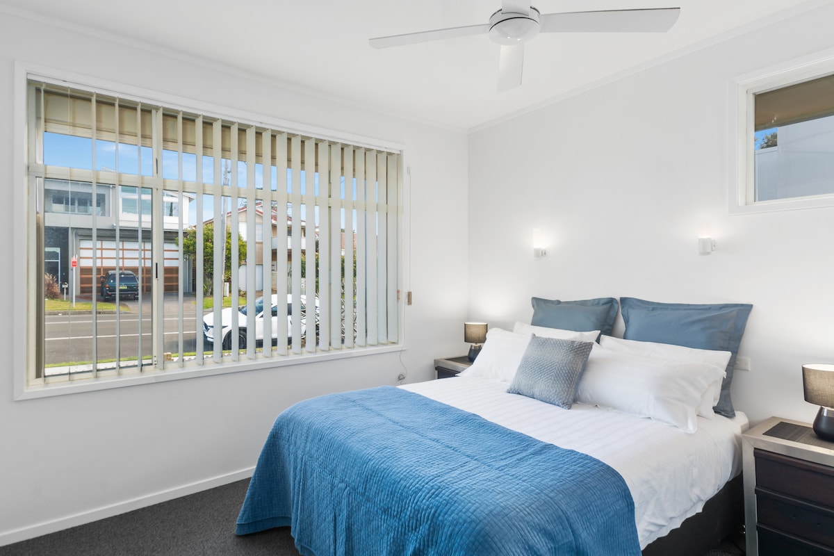 The neat master bedroom features coastal accents and offers a queen-bed and ceiling fan.
