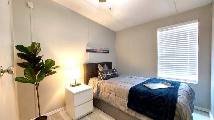 Dhoma e dytë e gjumit me dyshek me dy shkumë memorieje dhe abazhur me usb dhe jastëk karikimi pa kabllo.