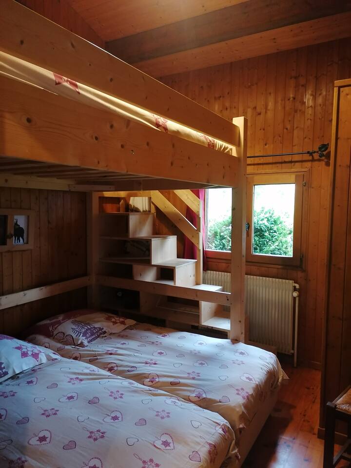 chambre avec un lit double en mezzanine et 2 lits simples
